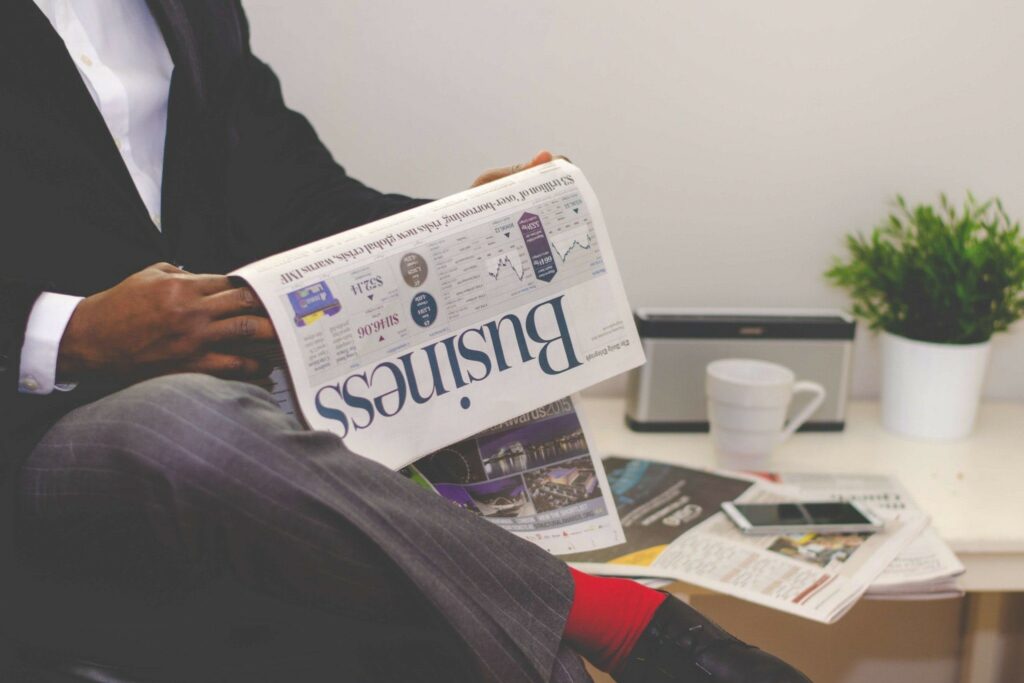 A businessperson reads the business section of a newspaper.