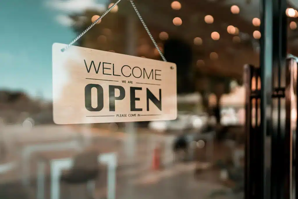 An open sign hanging on the door of a small business.