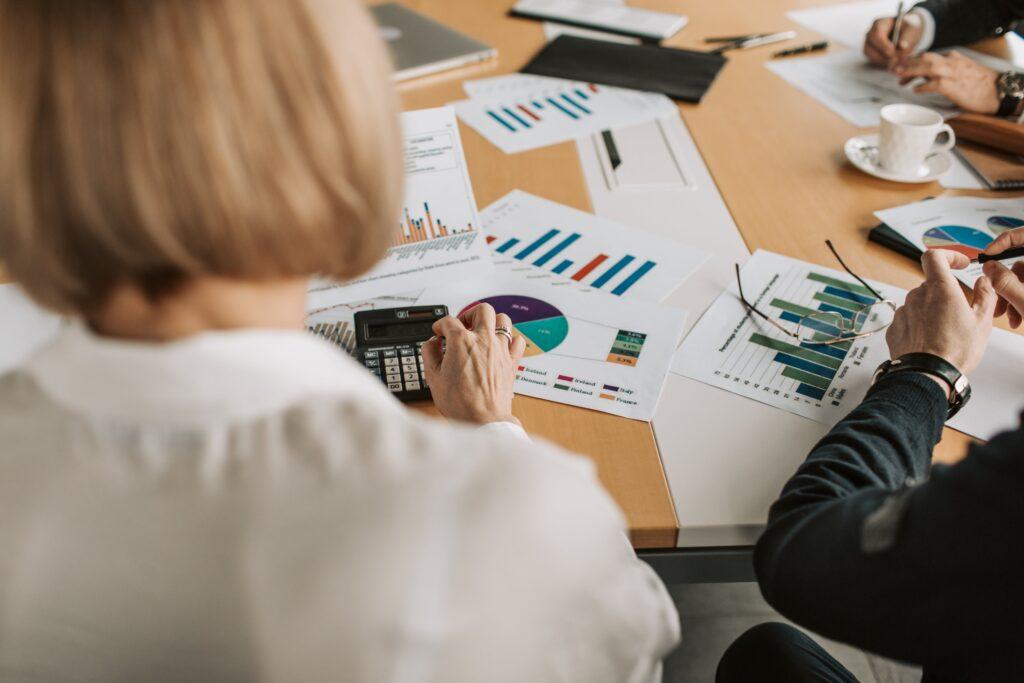Three lender employees look over a small business's financials.